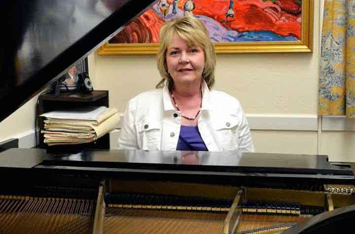 教员Ellen Hanson坐在她办公室的钢琴前