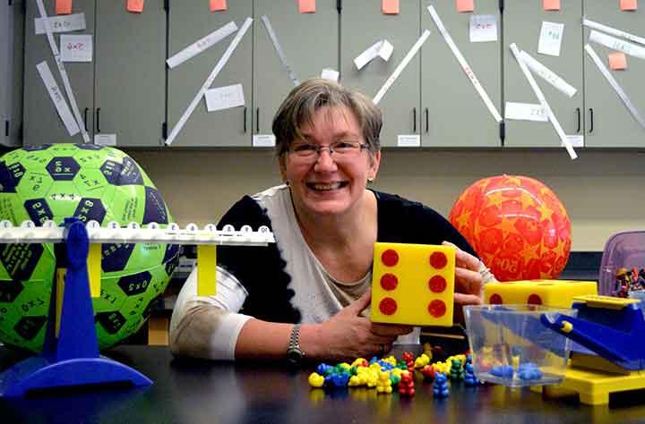 维吉尼亚B. 威尔科克斯被她用来帮助课堂教学的教育玩具包围着