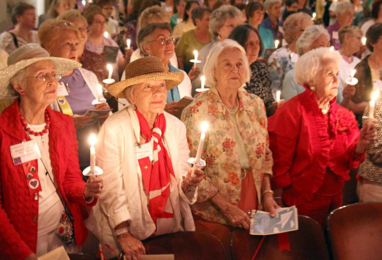 Alumnnae hold candles during ceremony in Porter