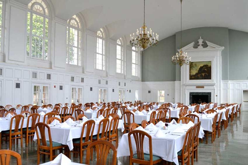 Wesleyan Dining hall with chandeliers, table clothes and napkins set up